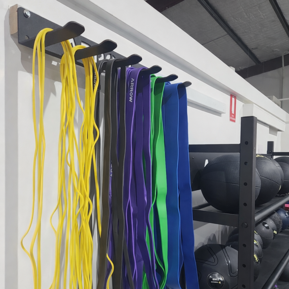 Colorful resistance bands hanging on a rack in a gym setting