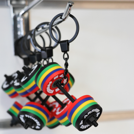 Colorful dumbbell-shaped keychains hanging on a keychain holder.