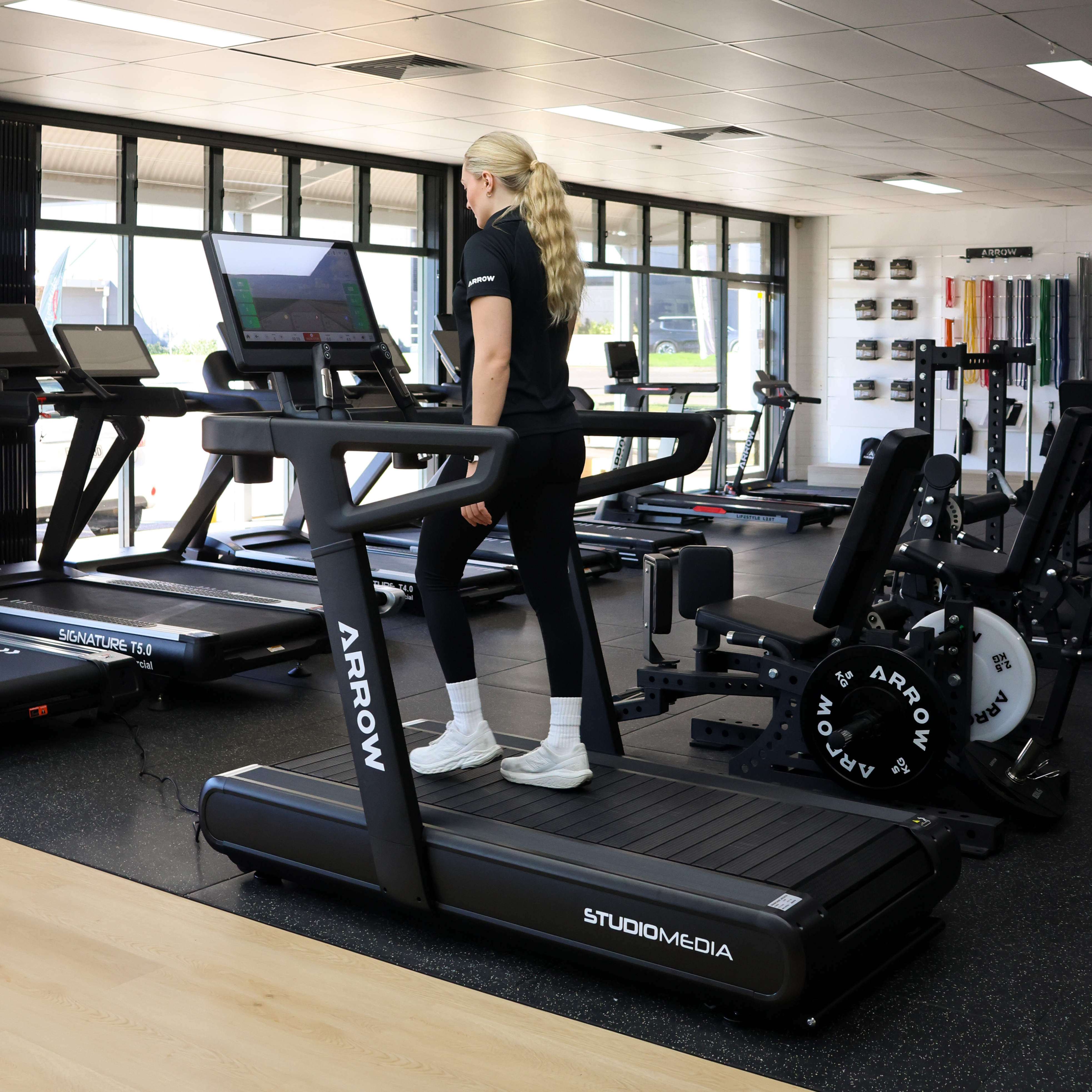 Treadmill in a gym setting with various exercise equipment around.