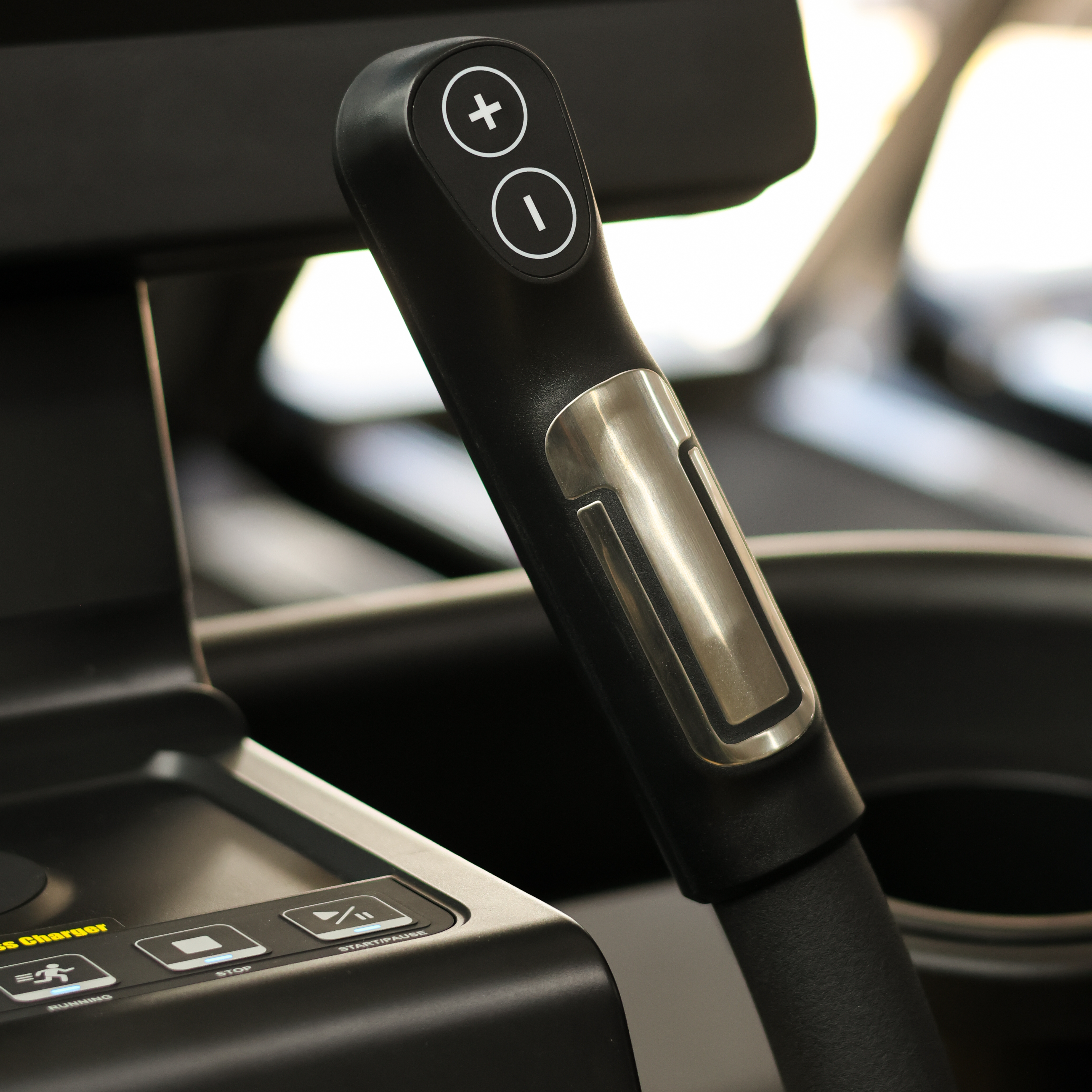 Close-up of a car audio control knob with blurred interior background